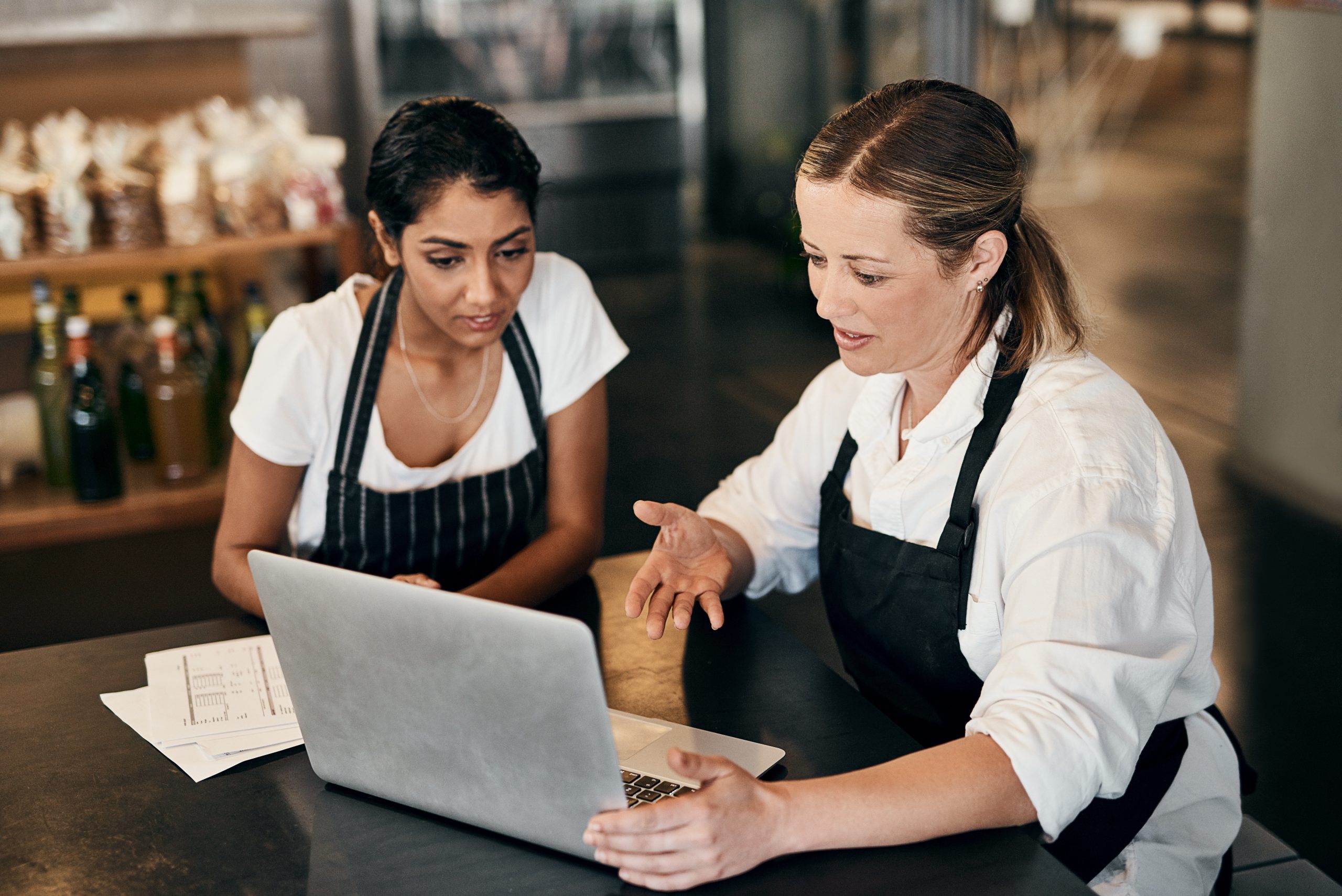 Restaurant team members reviewing payment information on a laptop